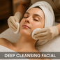 Woman receiving a deep cleansing facial with gloves and a towel on her head.