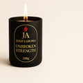 Candle with 'JA Josie's Aroma Unbroken Strength' label on a beige background