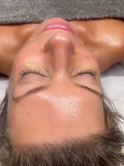 Close-up of a woman with clear glowing skin lying down during a luxury facial treatment in Swindon spa.
