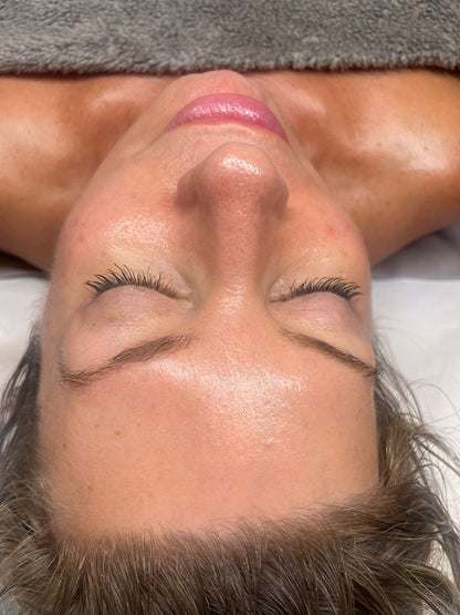 Close-up of a woman with glowing skin receiving a relaxing luxury facial treatment in Swindon spa.