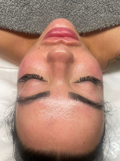 Close-up of a relaxed woman with glowing skin receiving a luxury facial treatment at a beauty salon in Swindon.