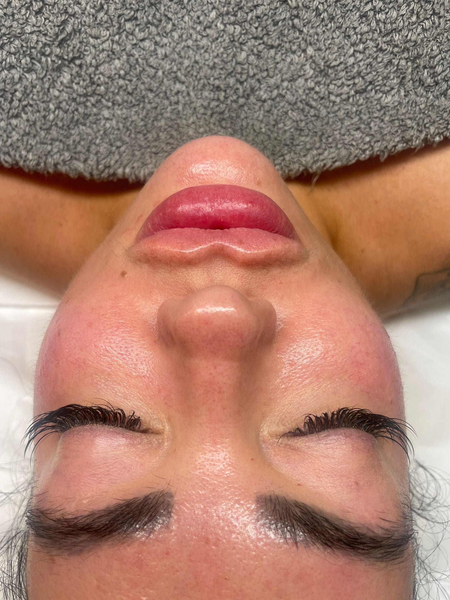 Close-up of a woman’s face with closed eyes receiving a luxury facial treatment on a spa bed.