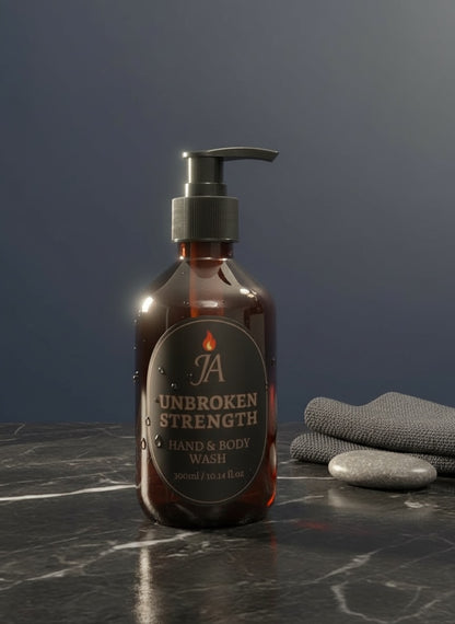 300ml bottle of Unbroken Strength Hand & Body Wash with amber packaging on marble surface and folded towel nearby