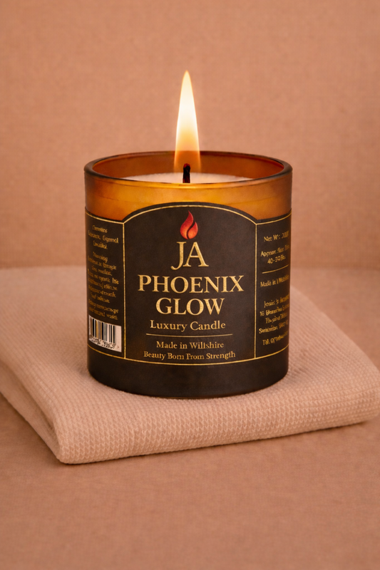 Lit JA Phoenix Glow luxury coconut scented candle on beige cloth with warm background tone
