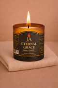Burning Eternal Grace luxury rosewood and velvet scented candle in amber glass jar on beige fabric